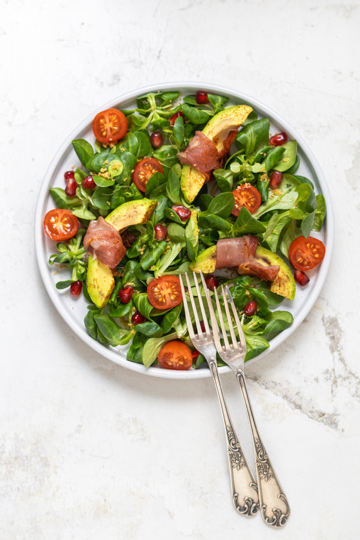 Insalata con involtini di avocado e prosciutto crudo